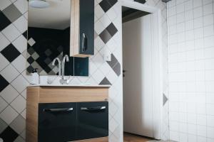 een keuken met zwarte kasten en een spoelbak bij Fabrica Apartments 22 in Cluj-Napoca +56 foto's