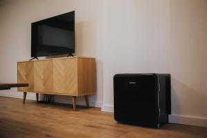 een televisie en een zwarte speaker naast een houten entertainmentcentrum bij Fabrica Apartments 22 in Cluj-Napoca