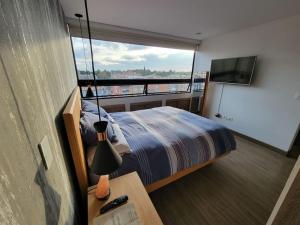ボゴタにあるLuxurious apartment in Cedritos, Bogotaのベッドルーム1室(ベッド1台、大きな窓付)