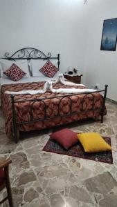 a bed in a room with pillows on the floor at La Casa del Sole in Giarre