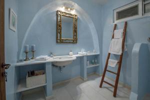 a blue bathroom with a sink and a mirror at Spetses Sea View Luxury House in Spetses