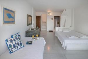 Habitación blanca con 2 camas y sofá en Spetses Sea View Luxury House, en Spetses