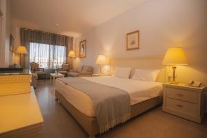 a hotel room with a bed and a living room at Grand Hotel Madaba in Madaba