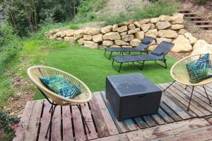 3 sedie e una televisione su una terrazza di legno di Cottage romantique, son jacuzzi privatif, piscine a Rillieux-la-Pape