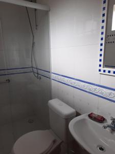 a white bathroom with a toilet and a sink at Nosso Pátio - Chalé na Montanha in Rancho Queimado