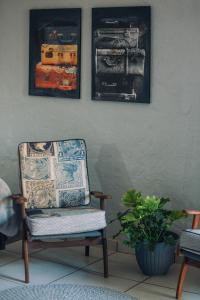 a chair in a room with two pictures on the wall at Blue Bell Guesthouse in Tzaneen