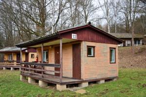 une petite maison en bois avec un panneau sur celle-ci dans l'établissement Areál Ontario Kyselka, à Kysibl Kyselka