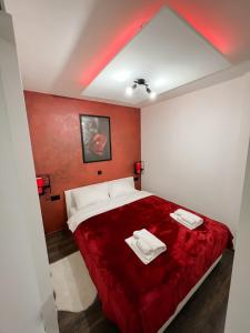 a red bedroom with a bed with two towels on it at Vinkovci 1 in Vinkovci