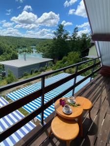 a table on a deck with a view of a river at Mrežnica - Zelena oaza in Generalski Stol
