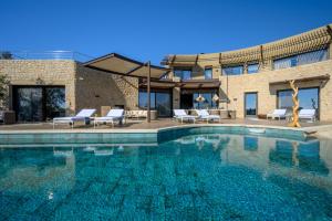 a swimming pool in front of a building at Captivating 5-Bedr Villa close Navarino Dunes Golf in Tragána