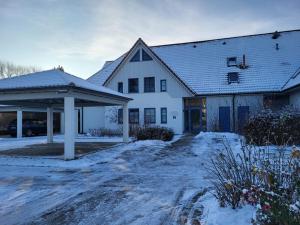 una casa blanca con nieve en el suelo en Oewern Diek 23, en Wustrow 22 fotos más