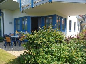 Una casa con un porche delantero azul con una mesa y sillas. en Oewern Diek 23, en Wustrow