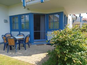 Un patio con una mesa y sillas frente a una casa. en Oewern Diek 23, en Wustrow