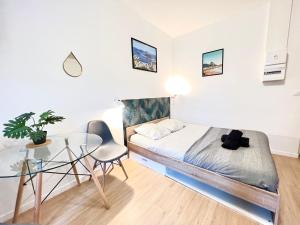 - une petite chambre avec un lit et une table en verre dans l'établissement Izicozy Studios - Immeuble Guillemot, à Châtellerault