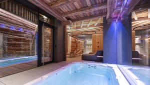 uma banheira de hidromassagem num quarto com tectos de madeira em Akchalet Akon em Livigno