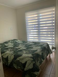 um quarto com uma cama e uma grande janela em Senderos em Coquimbo