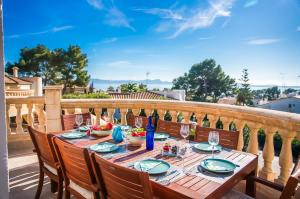 uma mesa numa varanda com garrafas de vinho e copos em Ideal Property Mallorca - Casa Osborne em Port d'Alcudia