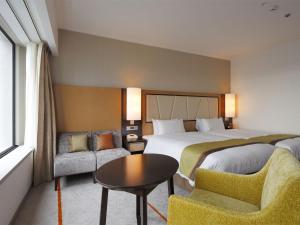 a hotel room with two beds and a table and chairs at Keio Plaza Hotel Tokyo in Tokyo