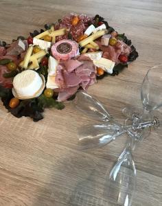 a plate of food on a table with a wine glass at Gîte Les Galipes in Mareuil-sur-Ay