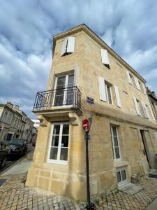 - un bâtiment en briques avec un balcon sur le côté dans l'établissement le loft bleu - un atelier-cocon élégant & central, à Bordeaux