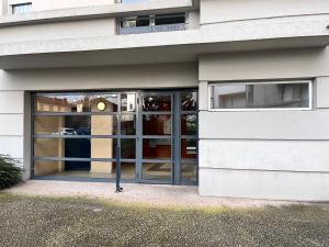 un accès à un bâtiment avec des portes en verre dans l'établissement Le Verrières - Appartement Cozy avec balcon proche de la gare, à Clermont-Ferrand