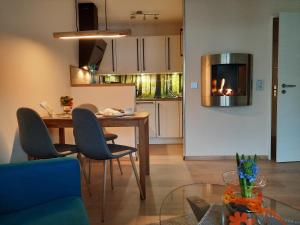 een woonkamer met een tafel en stoelen en een keuken bij Meisensuite in Hahnenklee-Bockswiese +3 foto's