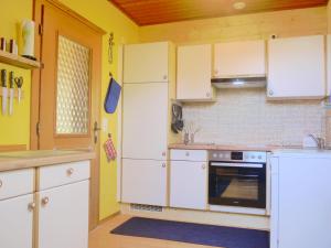 a kitchen with white cabinets and a stove at Haus Bellevue in Sankt Michael im Lungau