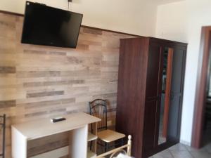 a room with a wooden wall with a flat screen tv at B&B Il Girasole in Assemini