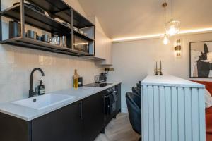 a kitchen with a sink and a living room at Chic Cotswold Tiny Home - Oddity House in Blockley