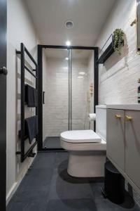 a bathroom with a toilet and a shower in it at Chic Cotswold Tiny Home - Oddity House in Blockley