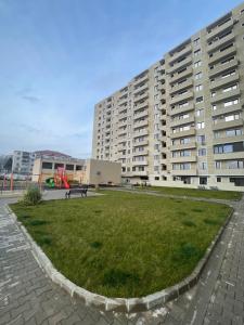 a park in front of a large apartment building at City View Apartment in Constanţa