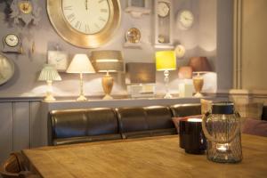 a living room with a table and a couch and a clock at The Fishbourne in Fishbourne