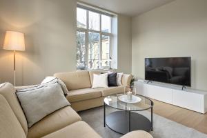 een woonkamer met een bank en een tv bij Elegant Bergen City Center Apartment - Ideal for business or leisure travelers in Bergen