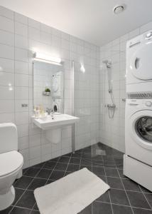 a bathroom with a toilet a sink and a washing machine at Elegant Bergen City Center Apartment - Ideal for business or leisure travelers in Bergen