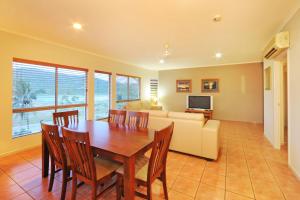 a dining room with a table and a couch at at Boathaven Bay Holiday Apartments in Airlie Beach