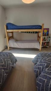 een slaapkamer met 2 bedden en een stapelbed bij Hermosa Casa Vistalba in Ciudad Lujan de Cuyo
