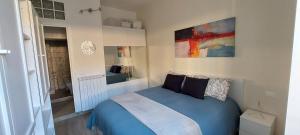 a bedroom with a blue bed and a painting on the wall at Alba Roma Holiday Home in Rome