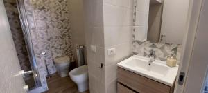 a white bathroom with a sink and a toilet at Alba Roma Holiday Home in Rome +20 photos