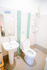 a bathroom with a toilet and a sink at Jazmine's Place in Coron