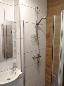 a bathroom with a shower and a sink at Pokoje Gościnne Perła in Brenna