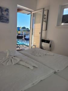 a white bed in a room with a balcony at 4 Sterne Dtv Floating House in Kröslin