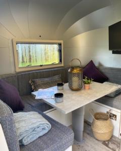 a living room with a table in a tiny house at Hall Farm Hideaway in Kings Lynn