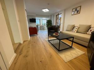 ヒンターツァルテンにあるSchöne Ferienwohnung am Alpersbach in Hinterzartenのソファとテーブルのあるリビングルーム +2枚の写真