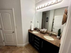 uma casa de banho com 2 lavatórios e um espelho grande em Tanglewood Condo em Hot Springs