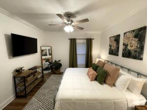 Schlafzimmer mit einem weißen Bett und einem Deckenventilator in der Unterkunft Tanglewood Condo in Hot Springs