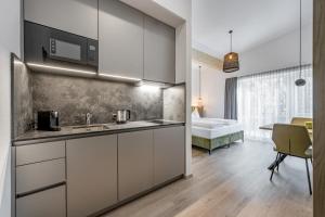 a kitchen with white cabinets and a bed in a room at Camping Sölden Apartments in Sölden