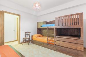 a bedroom with two bunk beds and a chair at Villetta Cala Rossa in Terrasini