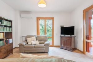 een woonkamer met een bank en een televisie bij Villetta Cala Rossa in Terrasini