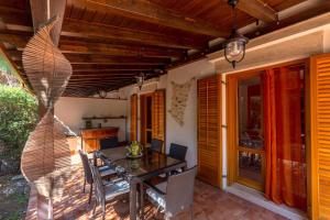 een patio met een tafel en stoelen op een veranda bij Villetta Cala Rossa in Terrasini