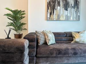un sofá marrón en una sala de estar con una maceta en HiGuests - Luxurious High-Rise Apartment With Stunning Views, en Dubái 61 fotos más